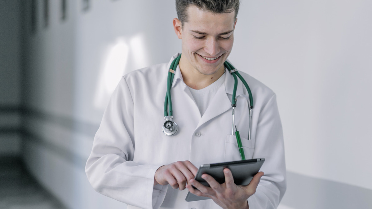 Profissional de saúde utilizando tablet para monitorar dados de pacientes em ambiente digital.